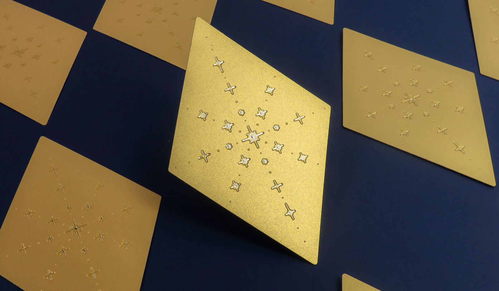 Tarjetas navideñas con forma de rombo, estampado oro y acabado Cristal sobre papel perlado Sirio Pearl Aurum.